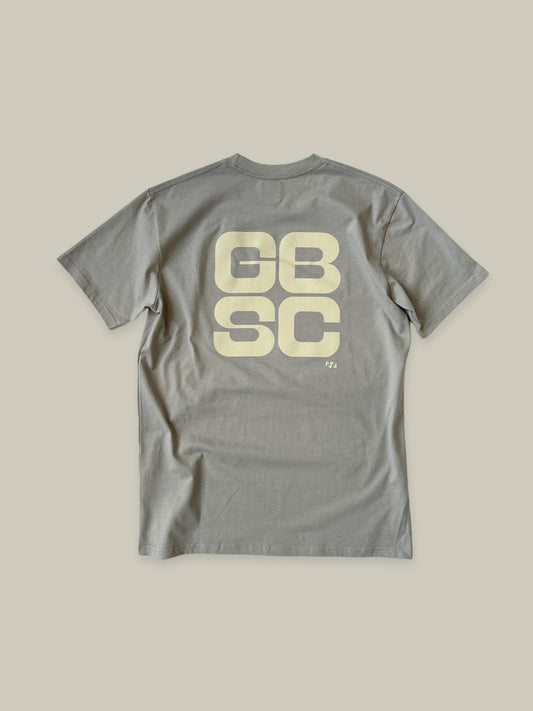 Full view of the back oversized GBSC graphic in beige, on the off-grey "storm" coloured Standard tee shirt